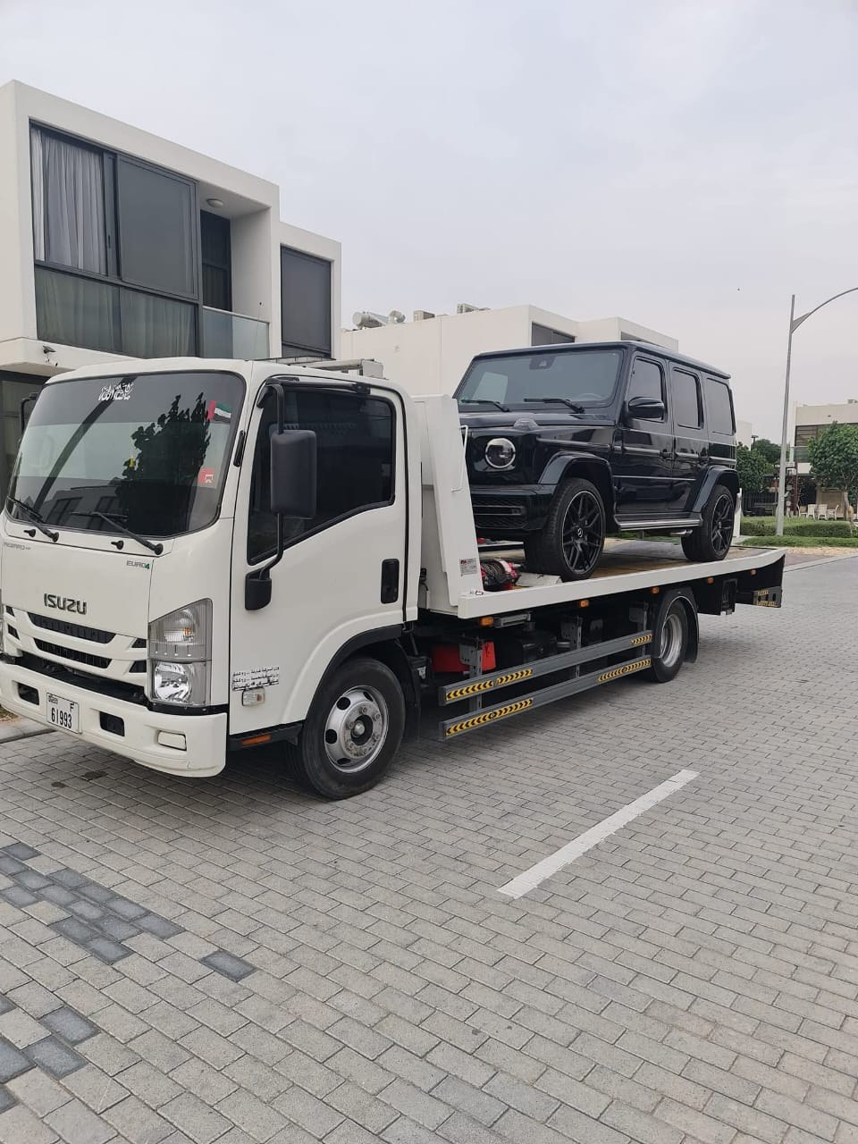 Behram Car Recovery - Black Mercedes G-Class on Isuzu flatbed truck in Dubai